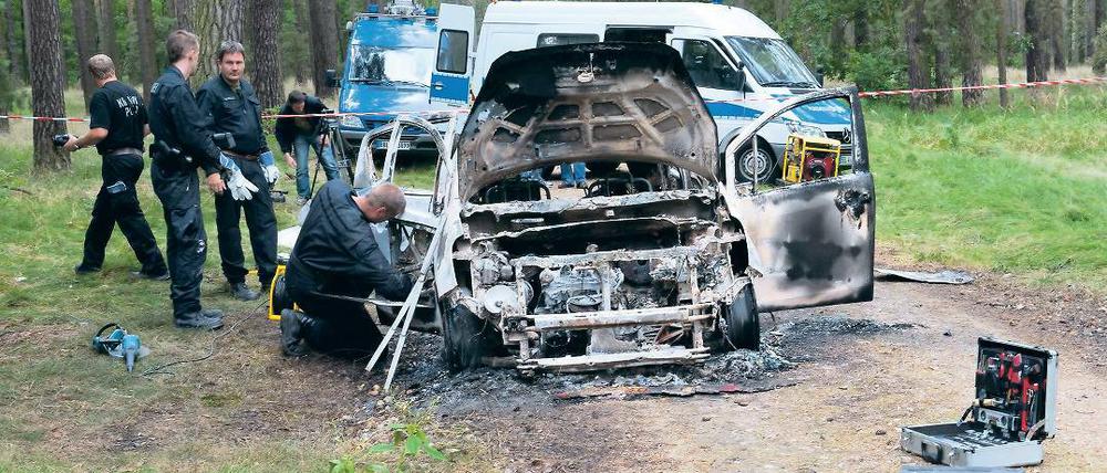 Grausiger Fund. Das ausgeglühte Auto wurde bei Börnicke gefunden. Polizisten sperrten das Areal ab.