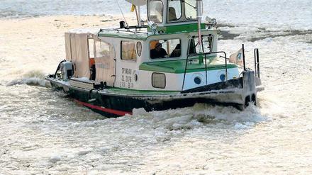 Mein lieber Scholli. Ein Boot kämpft sich durch die Eismassen auf der Spree.
