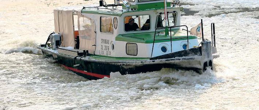 Mein lieber Scholli. Ein Boot kämpft sich durch die Eismassen auf der Spree.