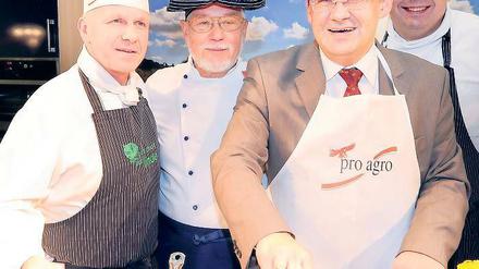 Hoch lebe die Region. Ralf Weißmann (l.) vom Gasthof Zur Linde in Wildenbruch überzeugt im Kochstudio Brandenburgs Agrarminister Jörg Vogelsänger (2.v.r.) das Frischeprodukte am besten schmecken. Eine Kochmütze für den Minister gab es gratis.