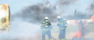 Brennende Flugzeugteile. Feuerwehrleute bei einer Notfallübung auf dem Flughafen Schönefeld. Bei dem Unfallszenario war eine notgelandete Maschine mit einem Tanklastwagen zusammengestoßen und zerschellt.