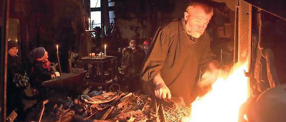 Staunen am Schmiedefeuer: Der Michendorfer Kunstschmied Michael Soika (vorne rechts) zeigte den Kindern der Potsdamer Kita „Friedenshaus“, wie man früher Schwerter herstellte. Bei den Kleinen dreht sich zurzeit alles um König Artus.