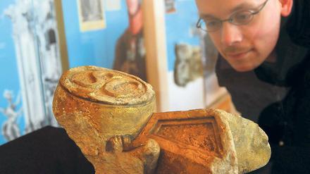 Bruchstücke der Geschichte. Ein Interessierter betrachtet Teile des Schwarzen Adlerordens aus der Mittelkonsole am Turmportal der Garnisonskirche, zu sehen in der neuen Ausstellung.