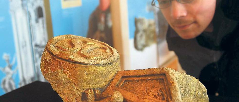 Bruchstücke der Geschichte. Ein Interessierter betrachtet Teile des Schwarzen Adlerordens aus der Mittelkonsole am Turmportal der Garnisonskirche, zu sehen in der neuen Ausstellung.