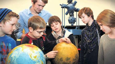 Erklärungen am Mondglobus. Der Astro-Klub in Aktion: Max-Leon, Aaron, Tilmann, Kilian und Felicia (v.l.n.r.) mit ihrem Klub-Leiter Simon Plate im Kuppelraum des Urania-Planetariums.