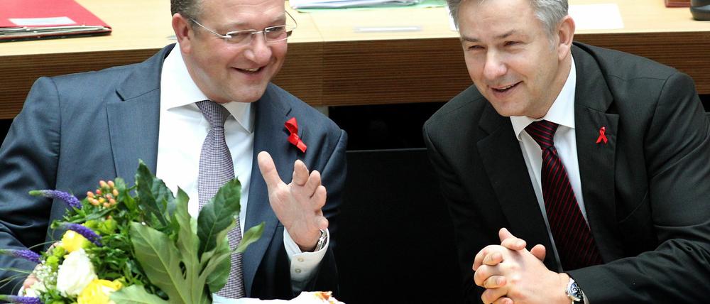 Der Regierende Bürgermeister, Klaus Wowereit (SPD, r), unterhält sich im Abgeordnetenhaus von Berlin mit Frank Henkel (CDU), Senator für Inneres und Sport. Zuvor hatten die neuen Senatoren ihren Amtseid abgelegt.