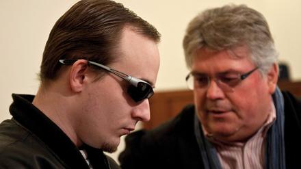 Der Angeklagte (l) und sein Rechtsanwalt Matthias Schöneburg sitzen im Gerichtssaal des Amtsgericht Zossen. Der mutmaßliche Anstifter eines rechtsextremistischen Brandanschlags in Zossen (Teltow-Fläming) steht seit Donnerstag vor Gericht. Der 25-Jährige gilt als Anführer der rechten Szene in Zossen und soll Jugendliche aufgefordert haben, im Januar 2010 das Haus der Demokratie anzuzünden. Die Potsdamer Staatsanwaltschaft wirft ihm Anstiftung zur Brandstiftung vor.