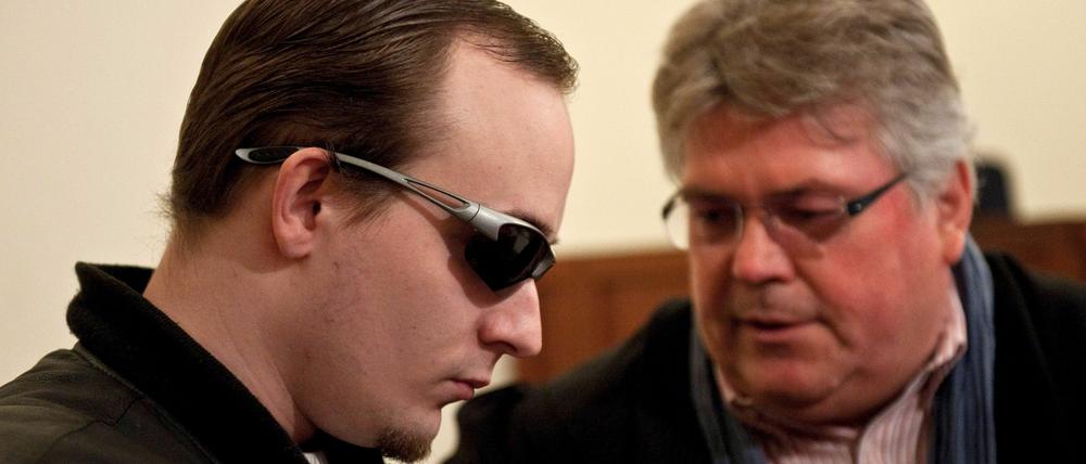 Der Angeklagte (l) und sein Rechtsanwalt Matthias Schöneburg sitzen im Gerichtssaal des Amtsgericht Zossen. Der mutmaßliche Anstifter eines rechtsextremistischen Brandanschlags in Zossen (Teltow-Fläming) steht seit Donnerstag vor Gericht. Der 25-Jährige gilt als Anführer der rechten Szene in Zossen und soll Jugendliche aufgefordert haben, im Januar 2010 das Haus der Demokratie anzuzünden. Die Potsdamer Staatsanwaltschaft wirft ihm Anstiftung zur Brandstiftung vor.