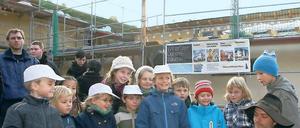 Krone und Modell. Kita-Kinder vor dem Rohbau ihres neuen Hauses.