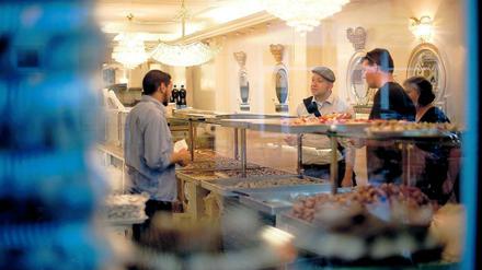 Jenseits von Museen. Der „Berlin-Greeter“ Hans Strömsdörfer (r.) unterwegs mit zwei australischen Touristen in einer türkischen Bäckerei im Stadtdteil Neu-Kölln in Berlin. Er zeigt ihnen die Stadt aus einer ganz persönlichen Perspektive.