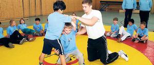 Auf der Potsdamer Ringermatte. Adrian Hofmann (rechts) kämpft mit dem RC Germania Potsdam um den Wiederaufstieg in die 2. Bundesliga und betreut als Landessichtungstrainer auch das Projekt "fairringeRn"; hier mit Alan Gol und Lucas Wege.