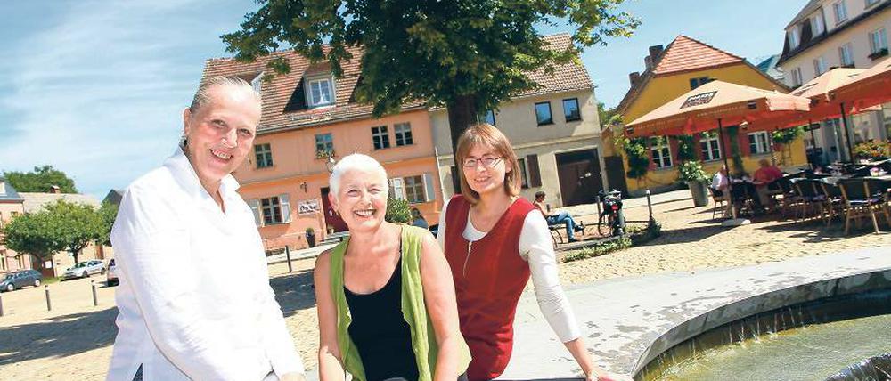 Mehr als nur Kulisse. Den pittoresken Marktplatz der Inselstadt Werder haben die Berlinerinnen richtig gern. In seinem Umkreis haben sie ihre Geschäfte eröffnet: Gabriele Wahl-Heidke den Antikladen im „schwarzen Haus“, Editha Stürtz-Frase das Café Olive, und Anja Möller eine Werkstatt für Designobjekte (v. l.).