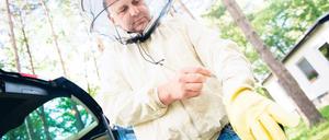 Beschützt. Imker Holger Ackermann legt seine Schutzausrüstung an, um ein Hornissennest zu begutachten.