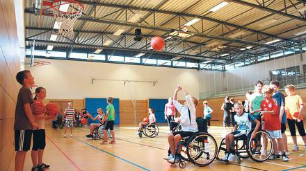 Erschwerte Bedingungen. Viel Kraft und Geschick ist notwendig, um den Ball vom Rolli aus in den Korb zu befördern.