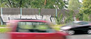 Aus Holz, aber vielleicht ohne Graffiti: So ähnlich wie hier am Stolper Weg soll auch die Lärmschutzwand am Stahnsdorfer Damm aussehen. Dort aber wird der rund vier Meter hohe Holzzaun fast über die gesamte Länge bis zur Schleuse von Bäumen verdeckt sein.