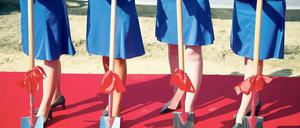 Herren schippten. Zur Grundsteinlegung reichten Hostessen die Spaten.