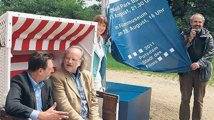 Platz in der Sonne. Jann Jakobs mit Komponist Peter Gotthardt, Bäderchefin Ute Sellow und Fahnen-Designer Peter Rogge (v.l.) und der Filmfahne vor dem Strandbad Babelsberg.