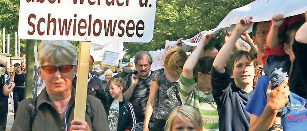 Protest „am laufenden Band“: Demonstranten mit Schild und Banner.