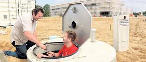 Schlüsselübergabe am künftigen Kreisgymnasium: Christian Siebert (r.) und Wolfgang Zöllner von der Tiefbaufirma TB-Service aus Ketzin installierten gestern in einem Schacht Pumpen für die Grünflächenbewässerung. Im Hintergrund die neue Sporthalle.