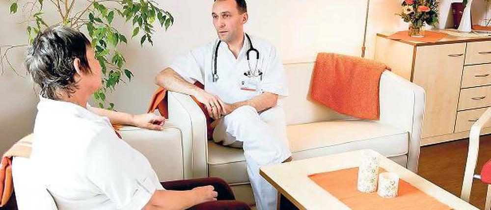 Im Wohnzimmer. Chefarzt Dr. Kämpfer mit einer Patientin.