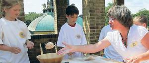 Backen an der Historischen Mühle: Sabine Jansen (r.) leitet die Kinder an.