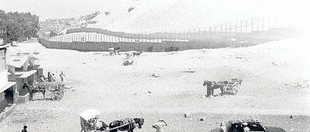 Unwirklich. Wie eine Filmkulisse wirkt diese wilde Bebauung im Sturm des Wüstenwindes am Rande der eingemauerten Pyramiden.