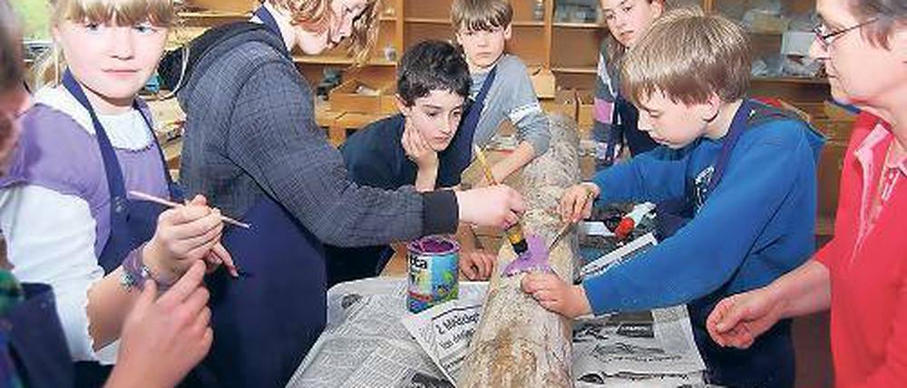 Fantasie gefragt. Kinder der 5. Klassen bearbeiten einen Baumstamm.