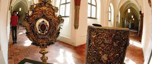 Eine Reliquienmonstranz mit dem Wappen des Abtes Gabriel aus dem Jahr 1716 (l.) und ein Missale Cisterciense (r.) und ein liturgisches Buch mit Texten fuer die Feier der Heiligen Messe nach dem Zisterzienserritus aus dem Jahr 1702, stehen im Kreuzgang von Kloster Neuzelle.