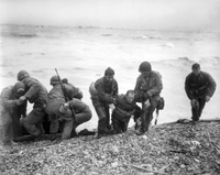 Soldaten einer amerikanischen Landeeinheit helfen ihren Kameraden während der Landung der alliierten Truppen an Land. (Archivbild 06.06.1944)