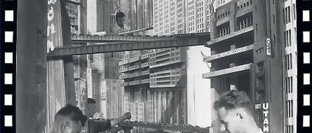 Zurück in die Zukunft. Der durch Metropolis brausende Verkehr wurde per Hand animiert. 300 Modellautos wurden für 2100 Einzelbilder millimeterweise bewegt, aus acht Tagen Arbeit wurden zehn Sekunden Film. Im Hintergrund ist der Neue Turm Babel zu sehen. Reales Vorbild für die Zukunftsstadt waren die Häuserschluchten von New York.