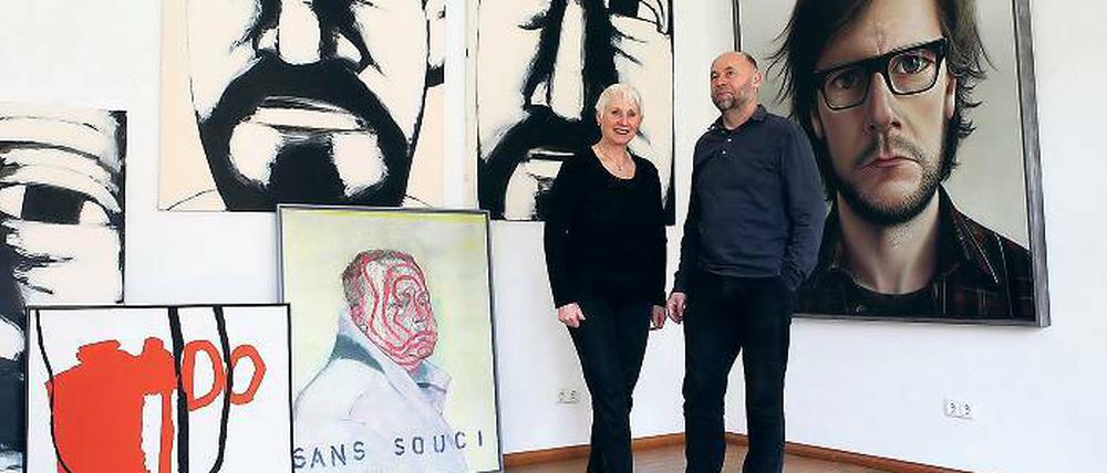 Inmitten ihrer Künstler: Ursula und Rainer Sperl flankiert von Selbstporträts, u.a. von den drei Köpfen Hans Hendrik Grimmlings (hinten), von Hans Scheuerecker, Stephan Velten und Alexander Gutsche (v.l.)
