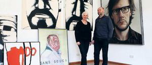 Inmitten ihrer Künstler: Ursula und Rainer Sperl flankiert von Selbstporträts, u.a. von den drei Köpfen Hans Hendrik Grimmlings (hinten), von Hans Scheuerecker, Stephan Velten und Alexander Gutsche (v.l.)