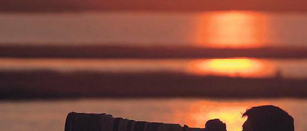 Beliebtes Motiv. Beim Sonnenuntergang wartet ein Fotograf auf Kraniche.