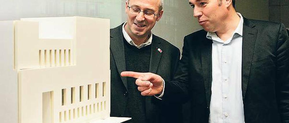 Das Haus in der Mitte der Straße. Architekt Jost Haberland (r.) und Norbert John, Technischer Geschäftsführer des Brandenburgischen Landesbetriebs für Liegenschaften und Bauen (BLB), mit einem Modell der umstrittenen Synagoge. Rechts im Bild die alte Synagoge am Platz der Einheit nach der Schändung in der Pogromnacht 1938.