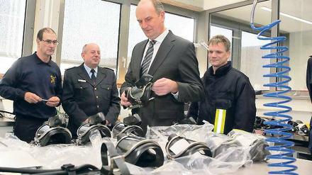 Modernste Technik. Funktionierende Atemschutzmasken sind für Feuerwehrleute lebenswichtig. Innenminister Dietmar Woidke (M.) ließ sich am Freitag vorführen, wie die Masken geprüft und dann für den nächsten Einsatz eingeschweißt werden.