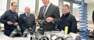 Modernste Technik. Funktionierende Atemschutzmasken sind für Feuerwehrleute lebenswichtig. Innenminister Dietmar Woidke (M.) ließ sich am Freitag vorführen, wie die Masken geprüft und dann für den nächsten Einsatz eingeschweißt werden.