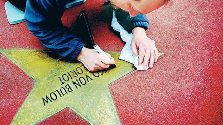 Neuer Glanz für Loriot: Bodo Lehmann malt Namen und Unterschriften der Promis auf dem Boulevard der Stars nach, hier den von Vicco von Bülow. Rechtzeitig zur Berlinale wurde Berlins Walk of Fame aufgehübscht.