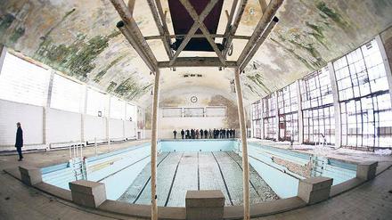 Ruinenarchitektur. Die frühere Schwimmhalle des Olympischen Dorfs soll für 1,6 Millionen Euro ein neues Dach erhalten. Nach einem Brandanschlag auf den Dachstuhl war der Bau jahrelang der Witterung ausgesetzt und wurde stark beschädigt.