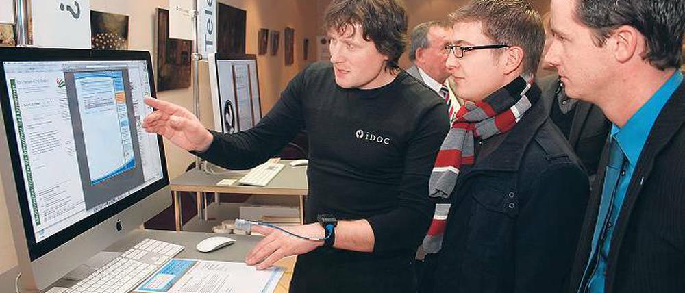 So klein wie eine Armbanduhr. Frank Golz (l.) vom Potsdamer iDoc-Institut erklärt die Wirkungsweise des iDoc-Messgeräts zur Selbstdiagnose von Schlafapnoe. Das Institut erhielt dafür gestern einen Preis im Bundeswettbewerb Land der Ideen.