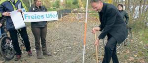 Symbolhaft: Baudezernent Matthias Klipp gestern beim Spatenstich für ein befestigtes Uferwegestück am Groß Glienicker See. Im Hintergrund ein gesperrtes Wegestück.