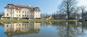Schloss Branitz spiegelt sich im Schlossteich auf dem Gelände vom Fürst-Pückler-Museum Park &amp; Schloss Branitz bei Cottbus.