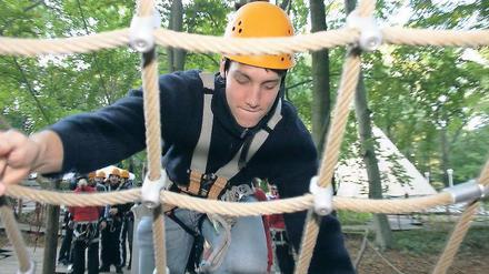 In den Wipfeln. Jakob Drachenberg (oben) hing tapfer in den Seilen, während sich Artur Tschigir (u. l.) anschnallen ließ. Trainer-Schwester Antje Laube (u. M.) war die einzige Dame im Herren-Team, das sich nach und nach durch den Wald hangelte (u. r.).