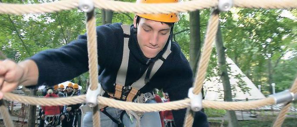In den Wipfeln. Jakob Drachenberg (oben) hing tapfer in den Seilen, während sich Artur Tschigir (u. l.) anschnallen ließ. Trainer-Schwester Antje Laube (u. M.) war die einzige Dame im Herren-Team, das sich nach und nach durch den Wald hangelte (u. r.).
