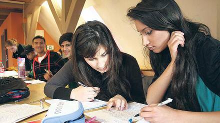 Bildungsferne Migranten? Von wegen! Die beiden Schülerinnen Saryeda (r.) und Farhat büffeln in der studentischen Hausaufgabenhilfe des Kuze. Die Studenten helfen bei englischen Aufsätzen oder höherer Mathematik.