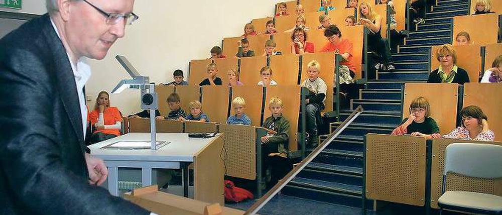 Eine schöne Erfahrung: Es ist Vorlesung und alle Plätze sind besetzt. Physik-Dekan Prof. Reimund Gerhard demonstriert die Klangerzeugung mit Hilfe eines Geigenbogens.