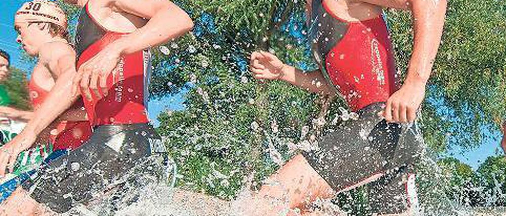 Durch die Fluten. Gregor Buchholz (rechts) und Franz Löschke (2. v. r.) starten am Samstag zum Abschluss der Bundesligasaison mit dem Potsdamer Zeppelin-Team beim Triathlon am Schliersee.