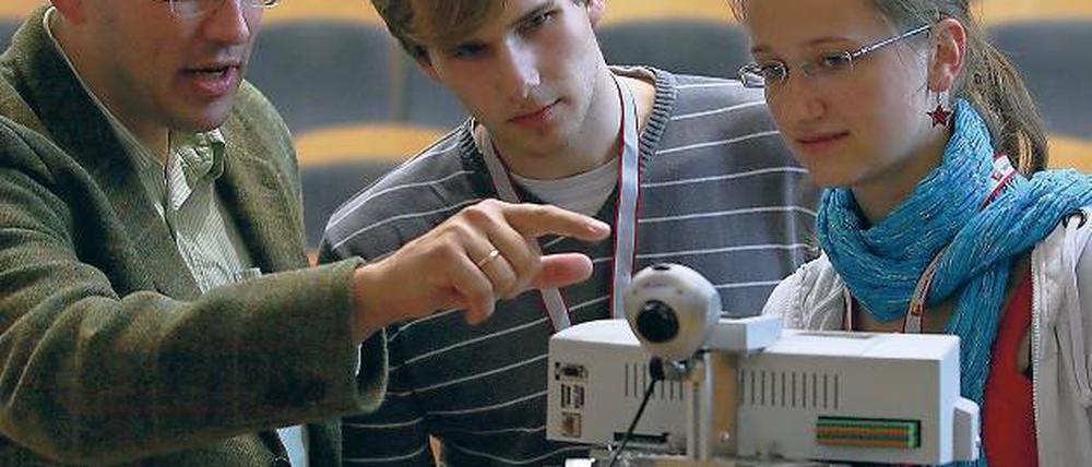Schülerkolleg 2010 am Hasso-Plattner-Institut. Professor Dr. Holger Giese erklärt den Potsdamern Lars Rückert und Ronja Paschke einen Robotino-Roboter, an dem sich die Schüler ausprobieren können.