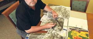 Warten auf den nächsten Bombenfund. Oranienburgs Bürgermeister Hans-Joachim Laesicke mit Luftaufnahmen, die Einschlagkrater von nicht explodierten Bomben dokumentieren.