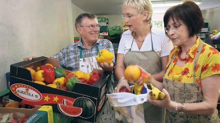 Essens-Allerlei im Beutel. Tafel-Mitarbeiter Manfred Krause weist Andrea Wicklein und Ingrid Raack (v.l.) in die Abläufe der Lebensmittel-Ausgabe ein: Alle Besucher kriegen von jeder Ware etwas in ihre Taschen  ob sie erst einmal wollen oder nicht.