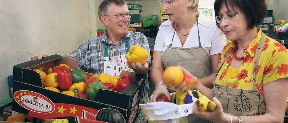 Essens-Allerlei im Beutel. Tafel-Mitarbeiter Manfred Krause weist Andrea Wicklein und Ingrid Raack (v.l.) in die Abläufe der Lebensmittel-Ausgabe ein: Alle Besucher kriegen von jeder Ware etwas in ihre Taschen  ob sie erst einmal wollen oder nicht.